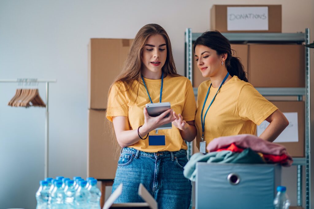 Couple of female volunteers working in community charity donation center